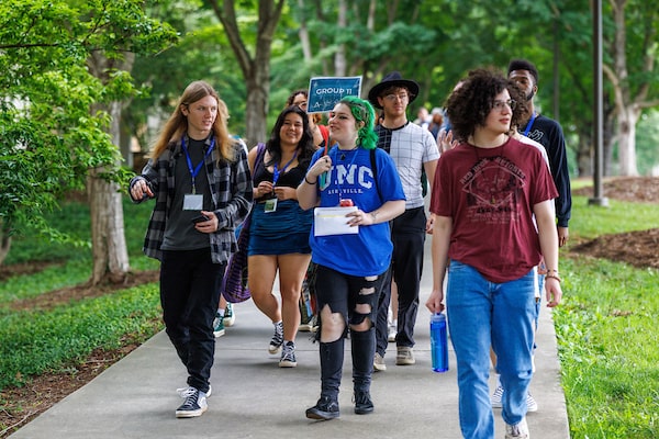A UNCA student leading a group of prospective students on a campus tour