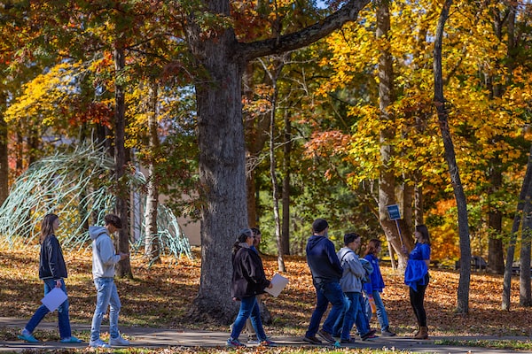 A UNCA student leading a group of prospective students and parents on a campus tour