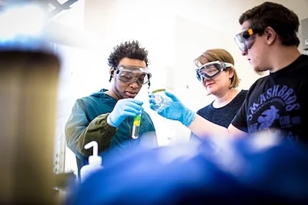 three UNCA students wearing goggles working in a lab