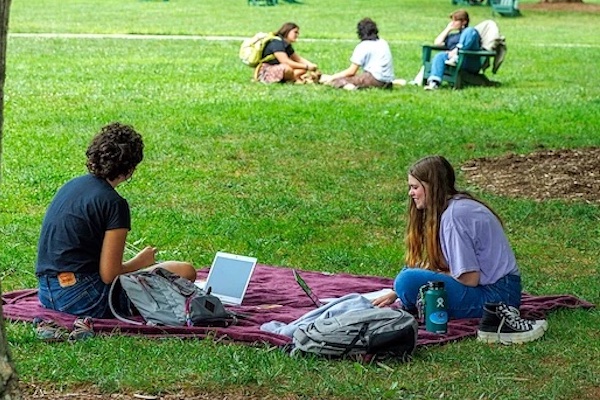 UNCA students studying while sitting outside on a blanket