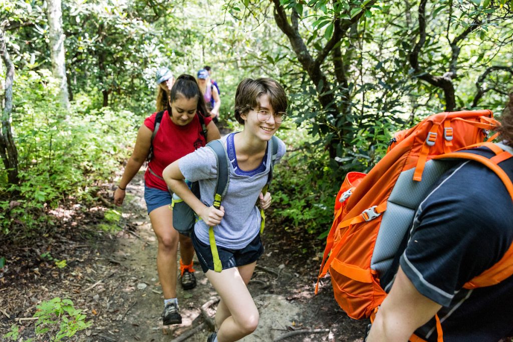 A group of UNC Asheville students backpacking through the woods.
