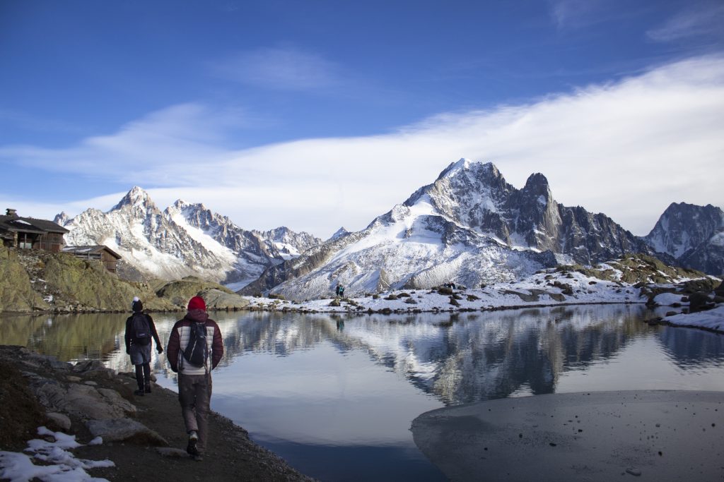 Two students walking with some large snowy mountains in the background