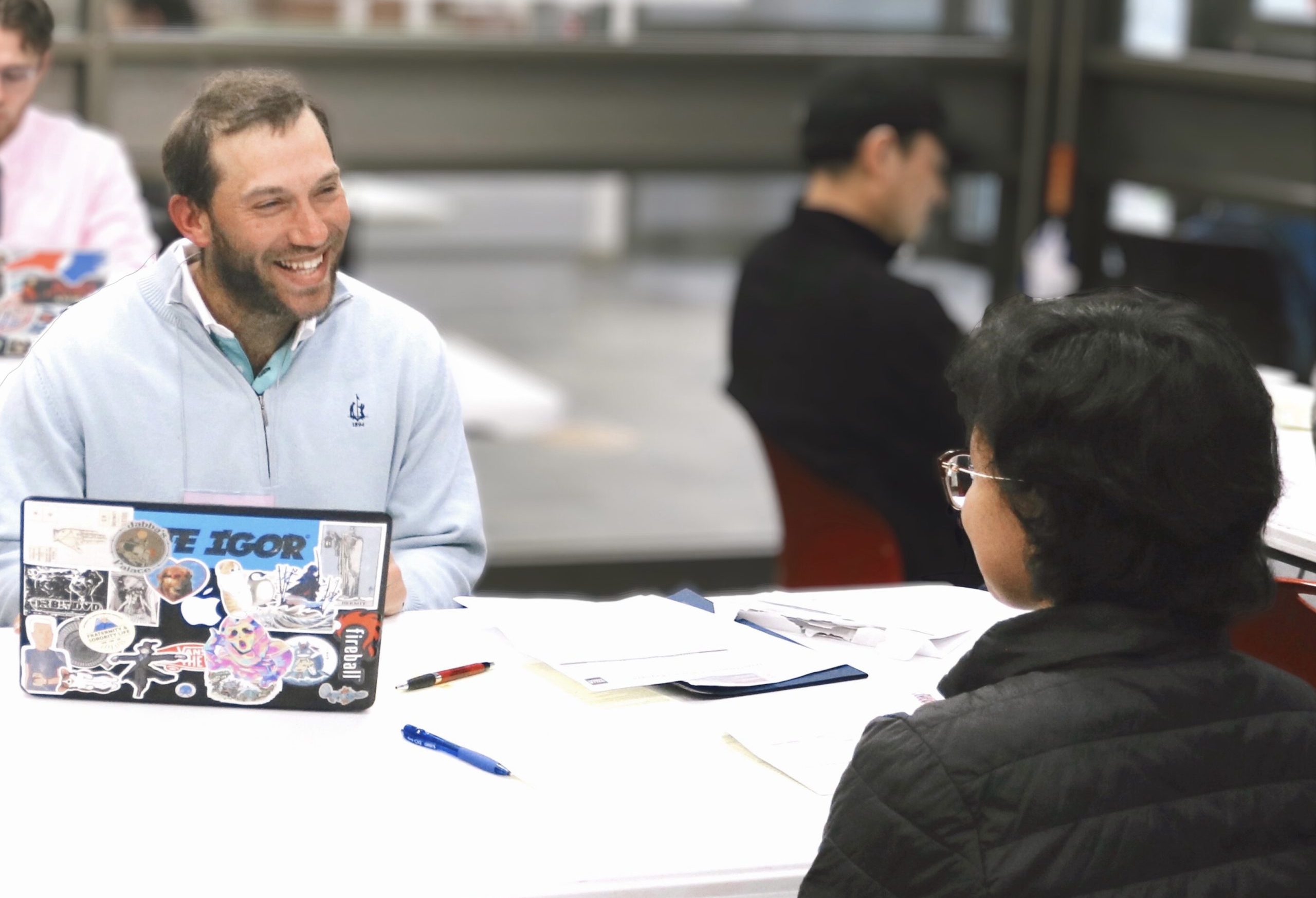 A business student sitting across a table from someone, talking