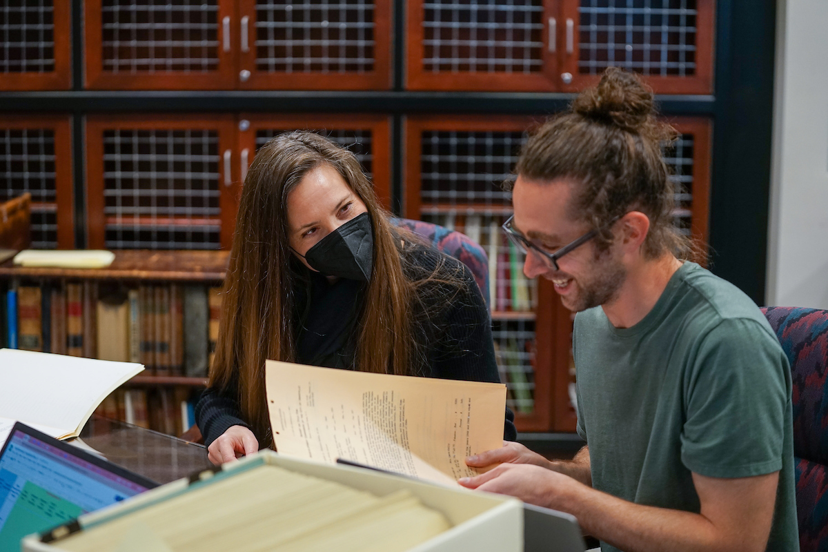 A student and a professor doing research in the university archives