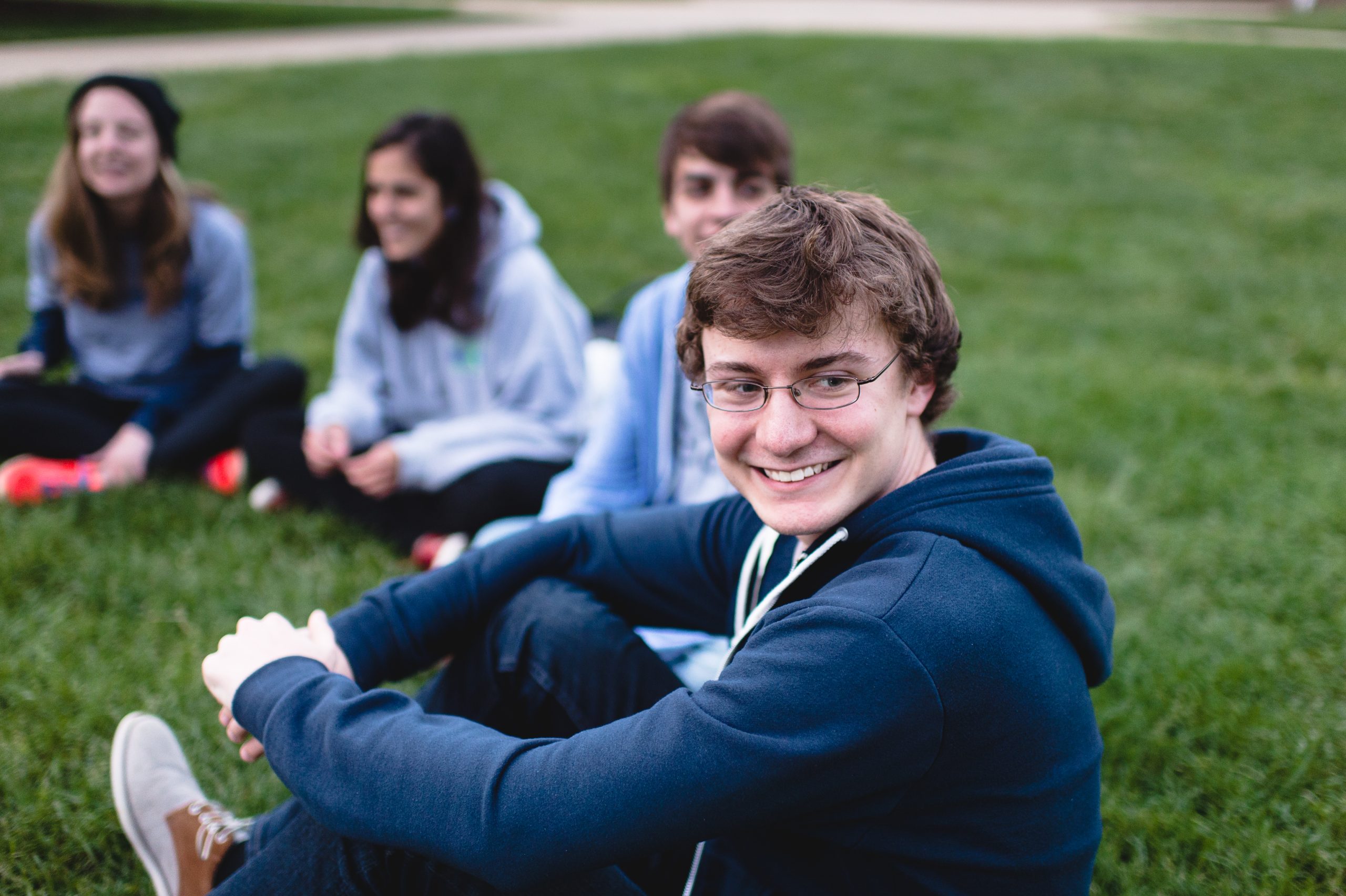 Students sitting on the quad in the grass
